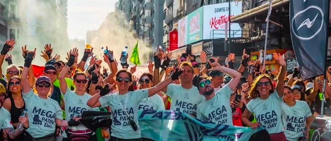 Coordinadores con remeras del MEGA PATINDAY festejando en la avenida